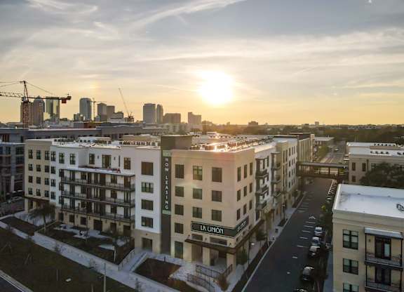 A sunset view of a cityscape with apartment buildings.
