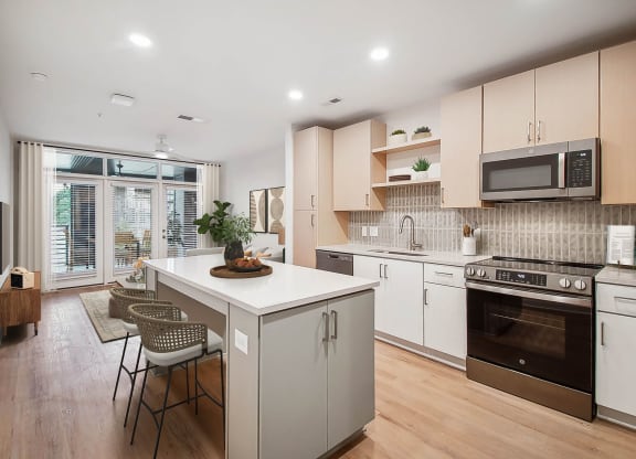 a kitchen with an island and a stove and a window at Hawkins Press Apartments, Charlotte