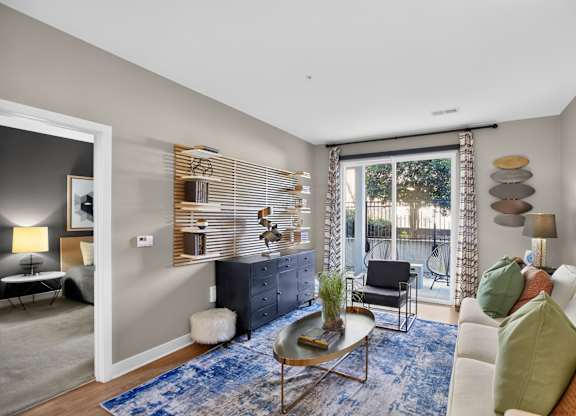 A living room with a blue rug and a white couch.