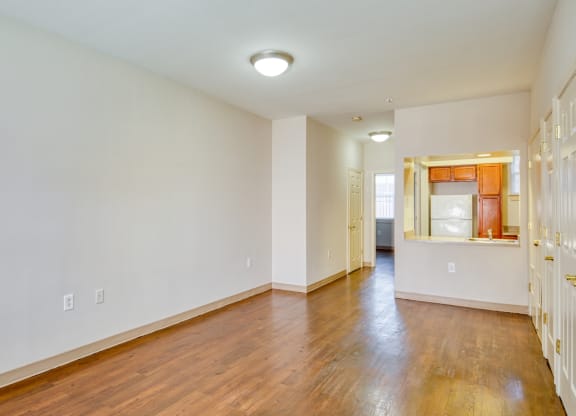 the living room and dining room of an empty house with wood floors and white walls at North Market South Carroll, Frederick Maryland
