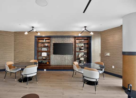 A modern dining room with a television and chairs.
