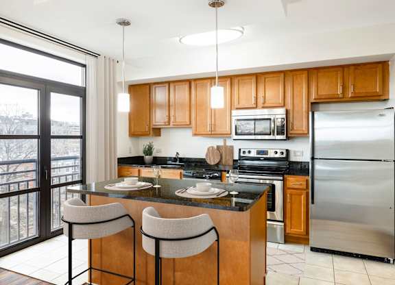 A kitchen with wooden cabinets and a black countertop. at Loree Grand at Union Place, Washington, 20002