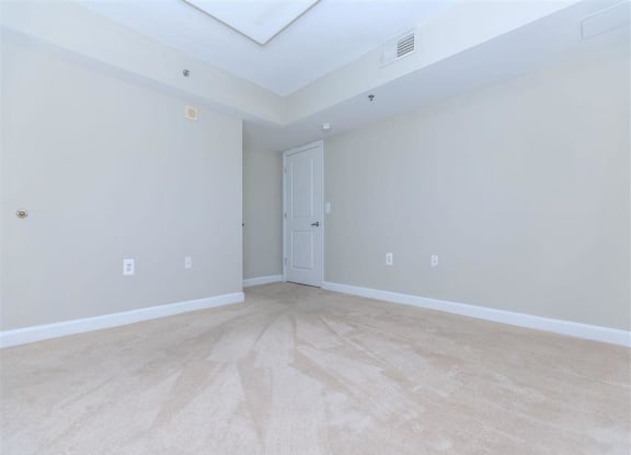 an empty bedroom with a door to a bathroom at The Gramax, Silver Spring, MD