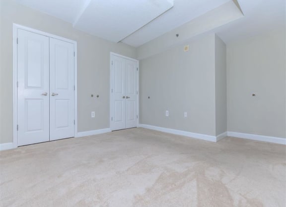 a bedroom with two doors and a carpeted floor at The Gramax, Silver Spring, MD, 20910