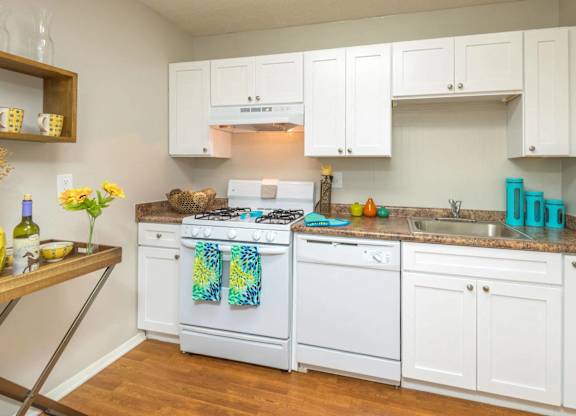 A kitchen with white cabinets and a white stove top oven.at The Pointe at Midtown, North Carolina, 27609