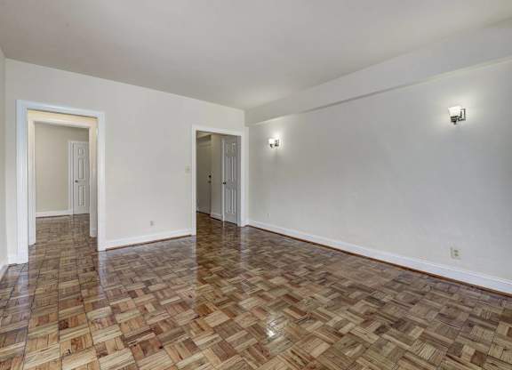 A room with a wooden floor and two doors.