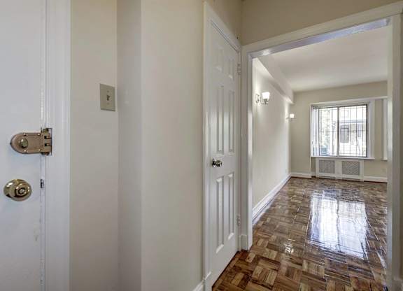 A hallway with a tiled floor and white walls.