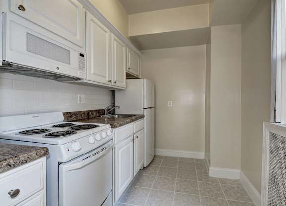 A kitchen with white appliances and cabinets.