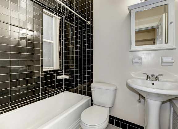 A white toilet sits next to a white sink in a bathroom.
