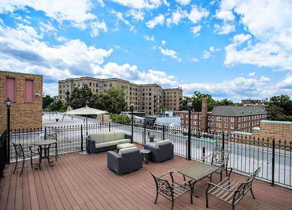 A patio with a table and chairs overlooking a cityscape.