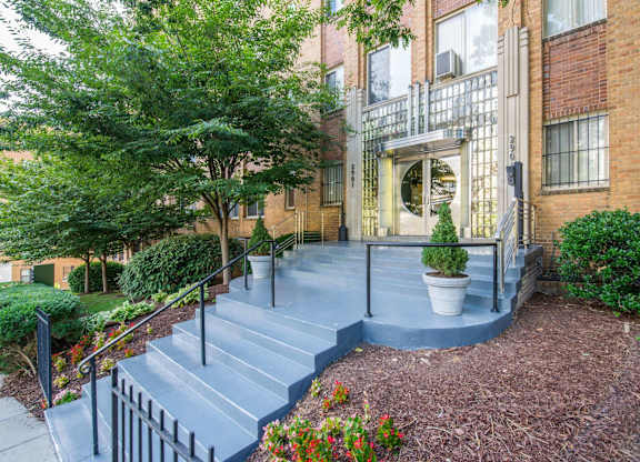 A courtyard with a staircase and a tree.