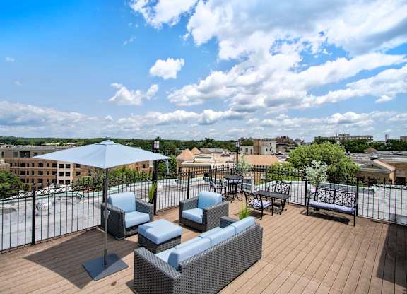 A patio with a table and chairs overlooking a cityscape.