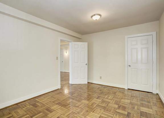 Empty bedroom with parquet floors and closet at Tivoli Gardens Apartments, Washington, 20010