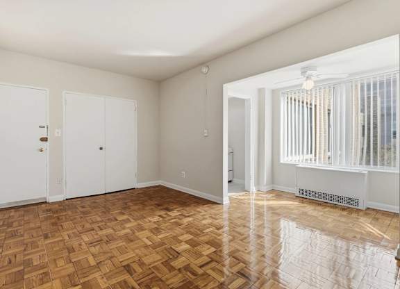 A room with wooden flooring and white walls.