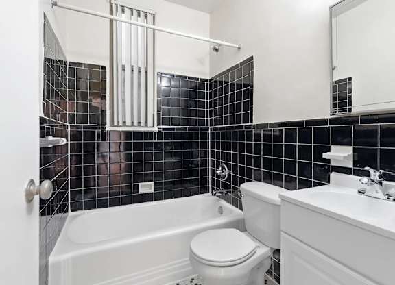 A bathroom with a white tub, toilet, and sink.