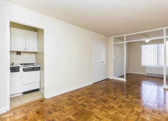 A kitchen with a stove top oven and a wooden floor.