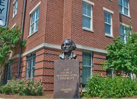 A brick building with a bust of a man and a sign that says