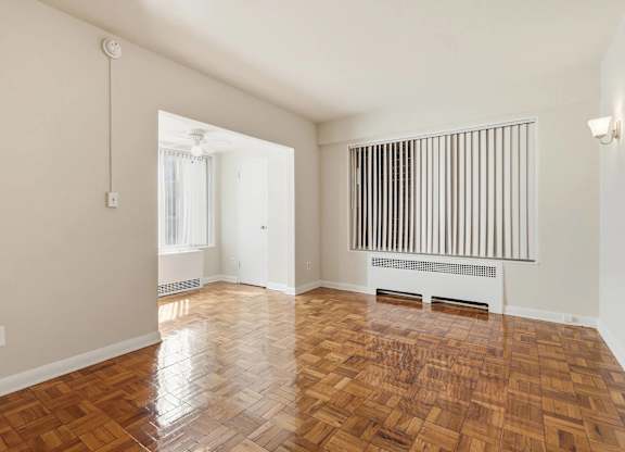 A room with wooden flooring and a radiator on the wall.
