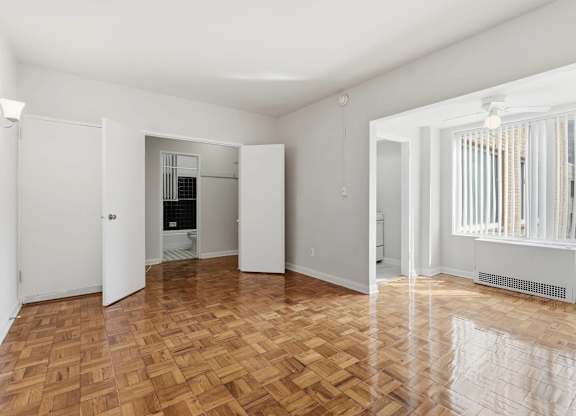 A room with wooden flooring and white walls.