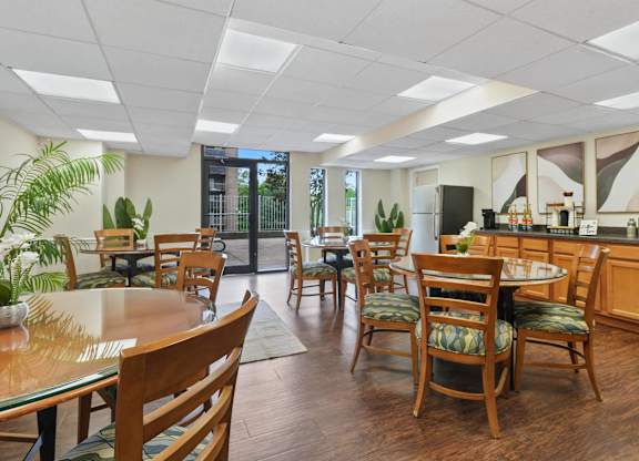 A kitchen with wooden chairs and tables.
