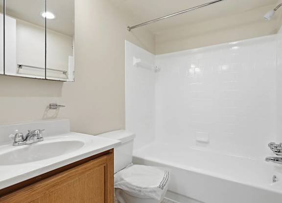 A white bathroom with a sink, toilet, and bathtub.