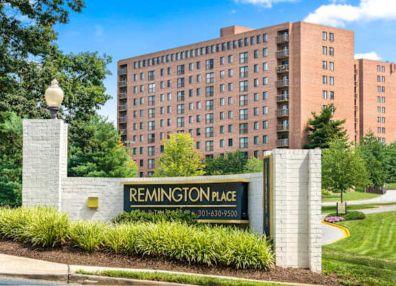 A sign for Remington Place stands in front of a building.