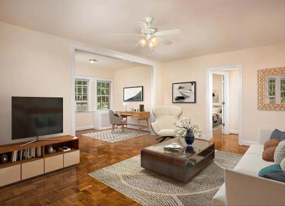 A living room with a white couch, a wooden coffee table, and a flat screen TV.