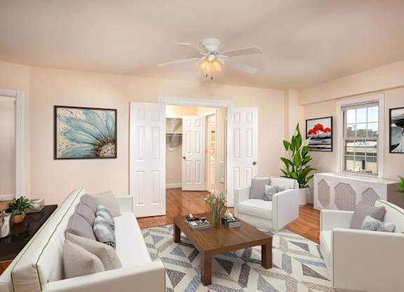 A living room with a white couch, a coffee table, and a ceiling fan.