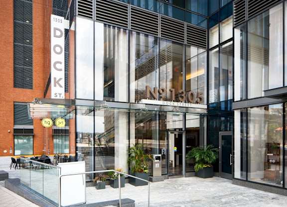 Modern glass building entrance with signage at 1305 Dock Apartments, Baltimore, Maryland