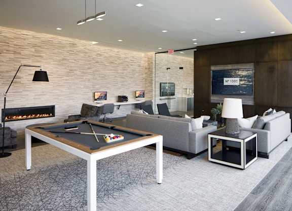 Modern lounge with pool table and fireplace at 1305 Dock Apartments, Baltimore