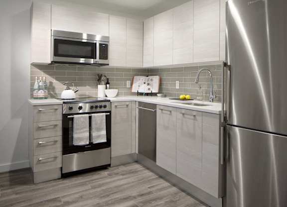 Modern kitchen with stainless steel appliances and subway tile at 1305 Dock Apartments, Baltimore, Maryland