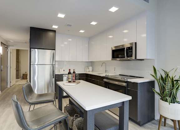 Modern kitchen with white countertops and island at 1405 Point Apartments, Maryland
