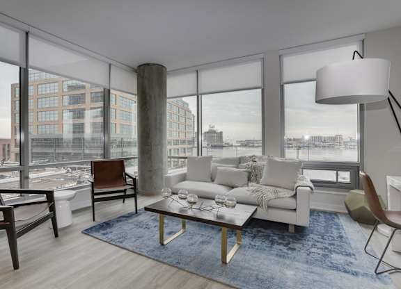 Modern living room with floor to ceiling windows at 1405 Point Apartments, Baltimore, Maryland