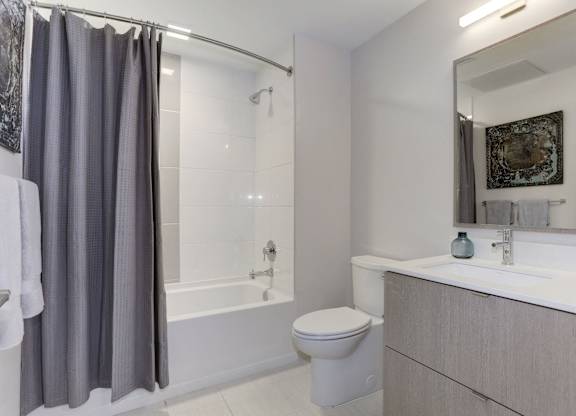 Modern bathroom with gray vanity and tub at 1405 Point Apartments, Maryland, 21231