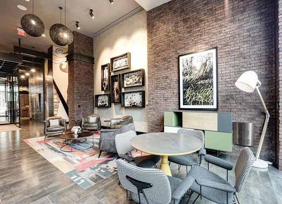 A room with a brick wall and a table with chairs.