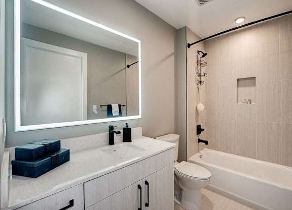A modern bathroom with a white sink and a white toilet.