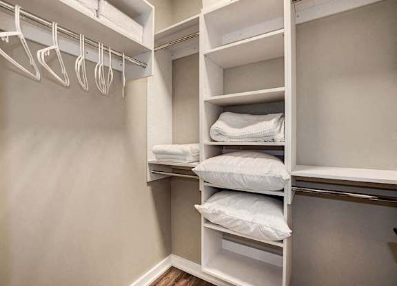 A white closet with shelves and hangers.