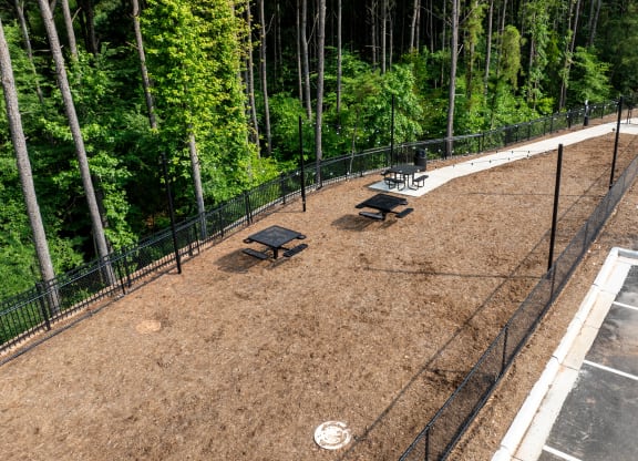 a fenced in dog park with benches and trees at Preston Ridge Apartments Cary, NC