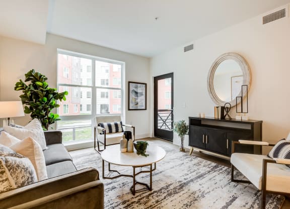 a living room with a couch and a table and a large window at Rialto, District of Columbia, 20002
