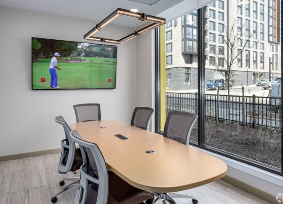 a conference room with a tv and a table with chairs
