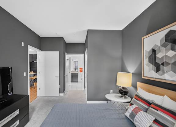 A modern bedroom with a large bed and a television.