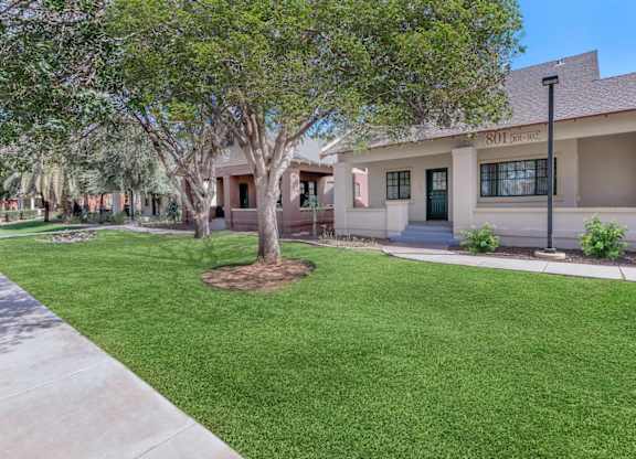 A tree in front of a building with the number 101 on it at Roosevelt Commons Apartments, Phoenix, AZ, 85003