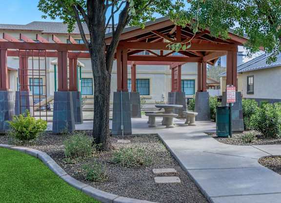 A covered outdoor seating area with a table and chairs at Roosevelt Commons Apartments, Phoenix, 85003