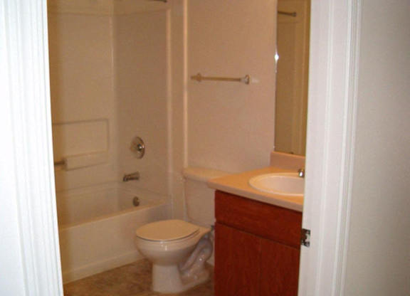 A white toilet sits in a bathroom next to a sink at Roosevelt Commons Apartments, Arizona