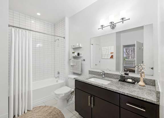 a white bathroom with a shower and a sink at Fort Totten Square, Washington DC