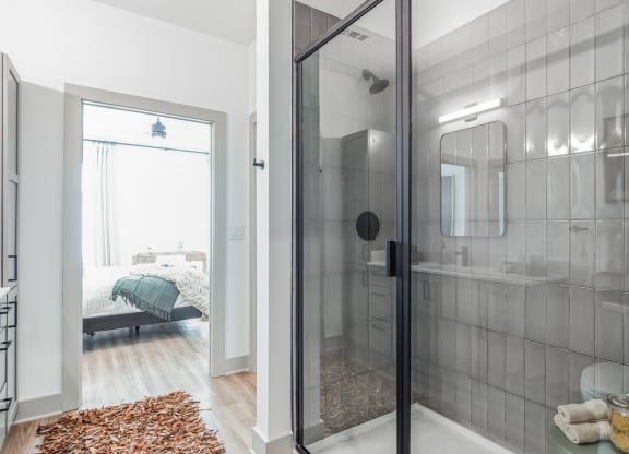 a bathroom with a glass shower and a bedroom with a bed at South and Hollis, Charlotte, NC, 28209