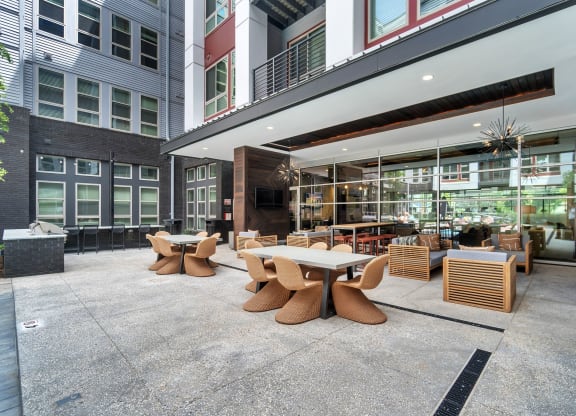 a patio with tables and chairs outside of a building at South and Hollis, Charlotte
