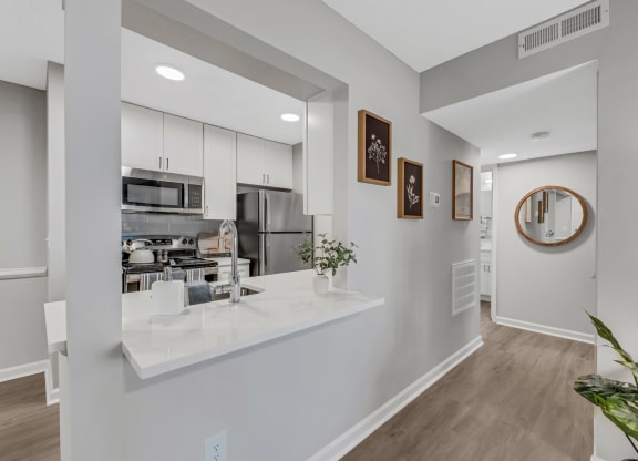a kitchen with white cabinetry and a white counter top with a vase of flowers on  at Brampton Moors, North Carolina, 27513