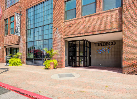 The front of a brick building with a glass door and windows.