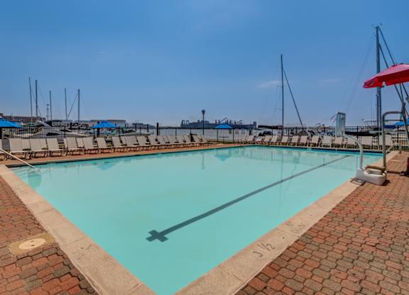 A rectangular pool with a brick border and a diving board.